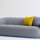 Sofá gris con almohada amarilla
