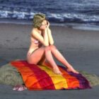 ビーチで毛布の上のビキニの若い女の子